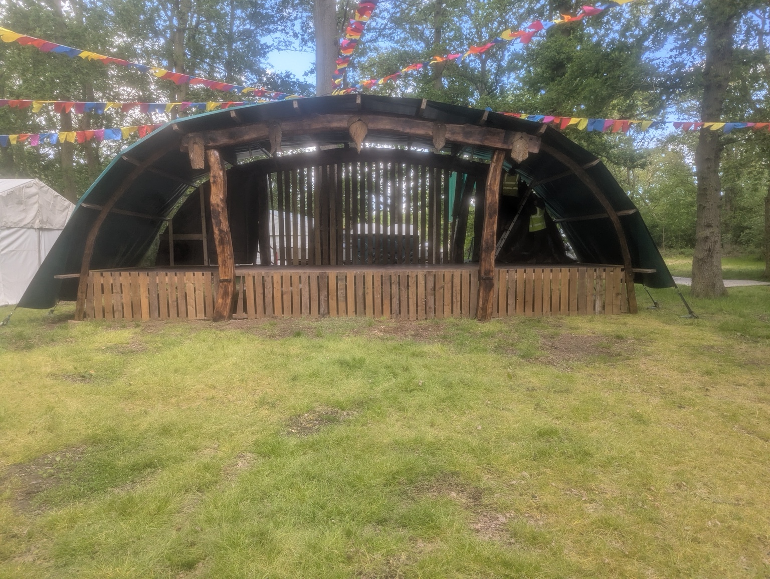 The wooden stage in a woodland setting with colourful festival bunting